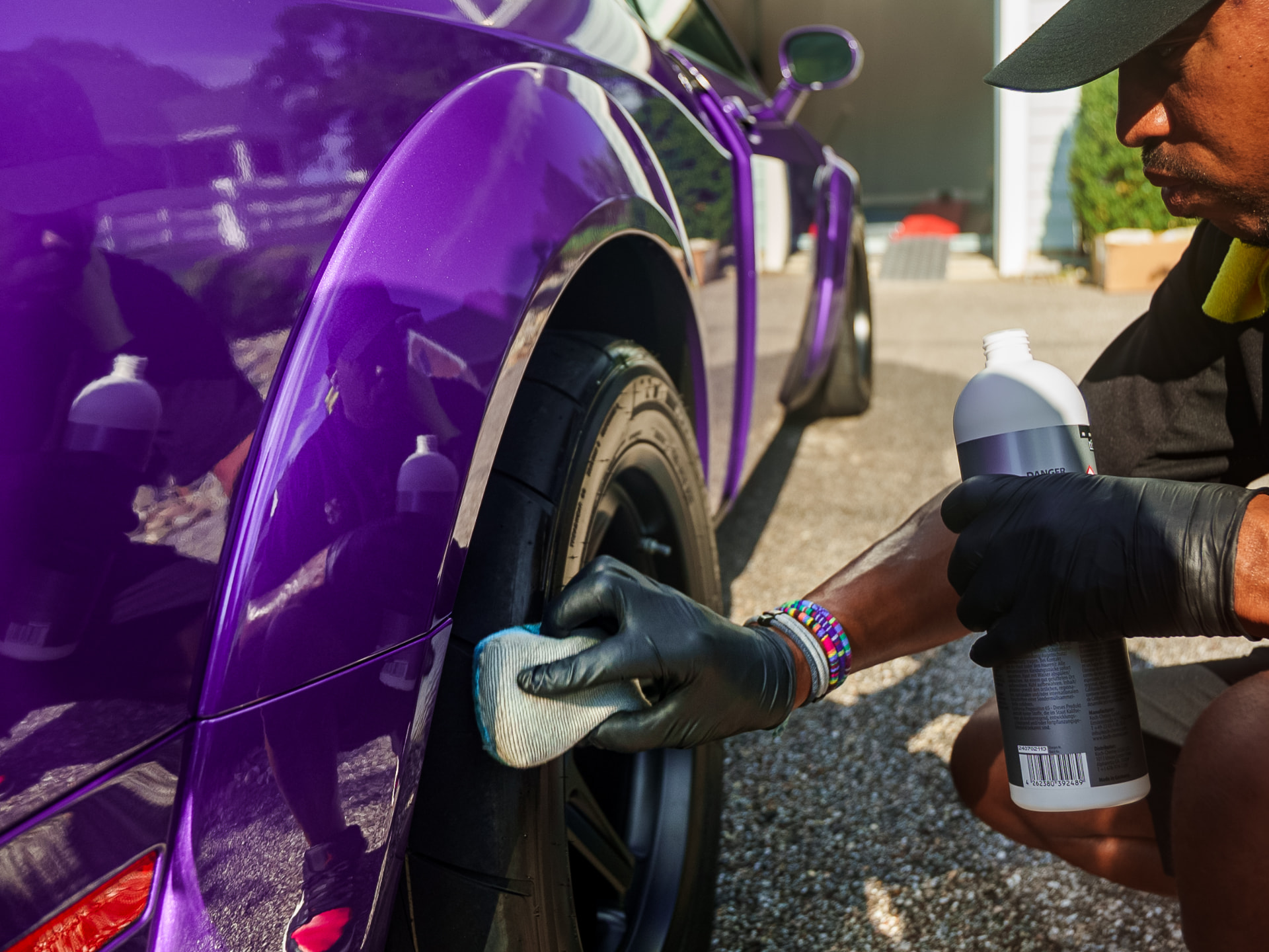 Apex detailer applying tire dressing to a purple car